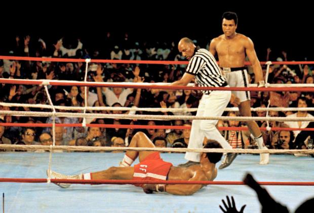 FILE - This is a Oct. 30, 1974 file photo of Muhammad Ali, right, as he stands back as referee Zack Clayton calls the count over opponent George Foreman, red shorts, in Kinshasa, Zaire. Ali won the fight in Africa by a knock out in the 8th round. It was 40 years ago that two men met just before dawn on Oct. 30, 1974, to earn $5 million in the Rumble in the Jungle. In one of boxing's most memorable moments, Muhammad Ali stopped the fearsome George Foreman to recapture the heavyweight title in the impoverished African nation of Zaire. (AP Photo, File)